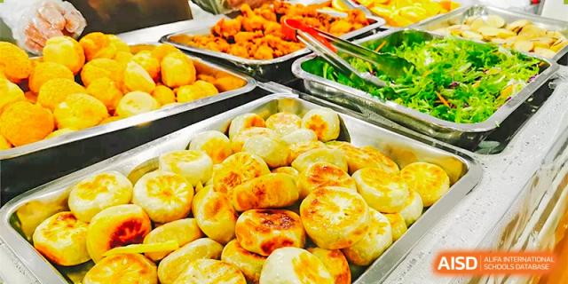 A tray of freshly baked golden pastries or dumplings being served in the cafeteria at The International School of Rhodes.