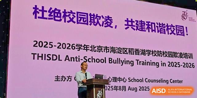 An adult speaker presenting on stage about an anti-school bullying initiative at Tsinghua International School Daoxiang Lake.