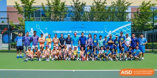 A large group of students and staff from Tsinghua International School Daoxiang Lake posing for a picture on a green field.