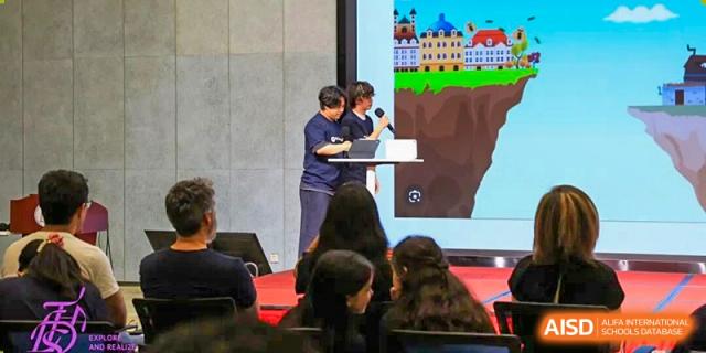 An adult presenting information to a group of seated students in a classroom or lecture hall at Tsinghua International School Daoxiang Lake.