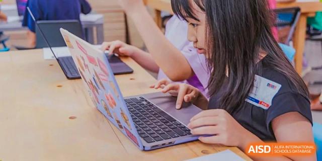 A student at American International School of Guangzhou (AISG) works on a project or assignment using a laptop computer.