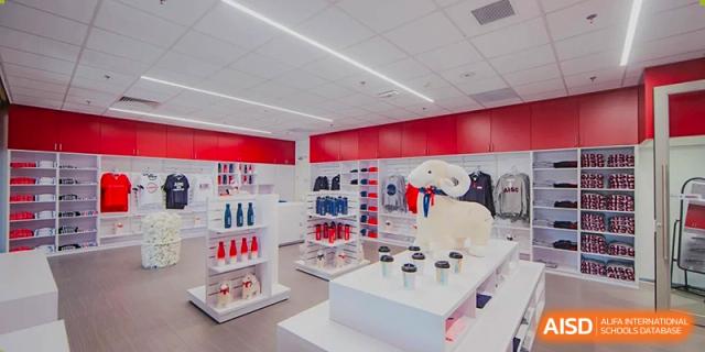The brightly lit school store or uniform shop at American International School of Guangzhou (AISG), featuring school merchandise and clothing displays.