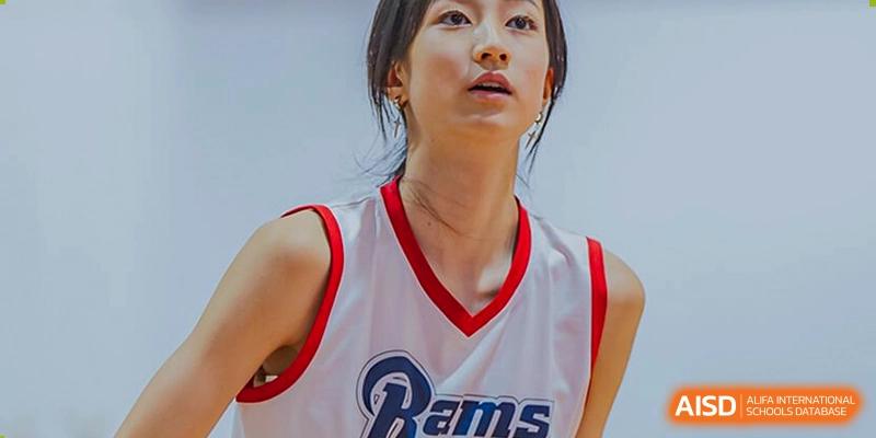 A close-up shot of a female student wearing a white "Rams" basketball jersey at the American International School of Guangzhou (AISG).