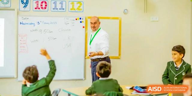 A male teacher writing on a whiteboard while teaching a class on China to a group of students at Britannia International School Guangzhou.