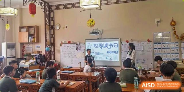 Students seated at traditional wooden desks in a classroom with Chinese characters written on the whiteboard at Britannia International School Guangzhou.