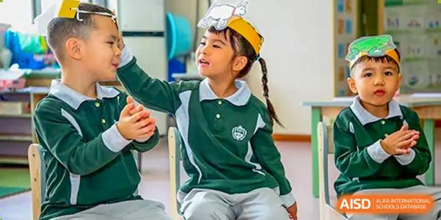 Close-up of a young student in a green and white school uniform seated in a classroom at Britannia International School Guangzhou.