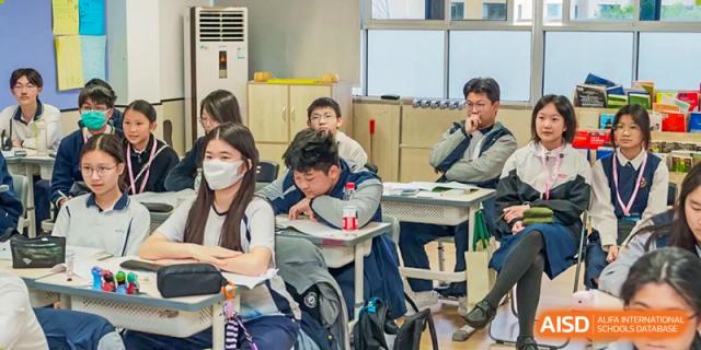 Students in uniforms working at their desks, with some wearing masks, during a class at the Affiliated School of JNU for Hong Kong & Macao Students.