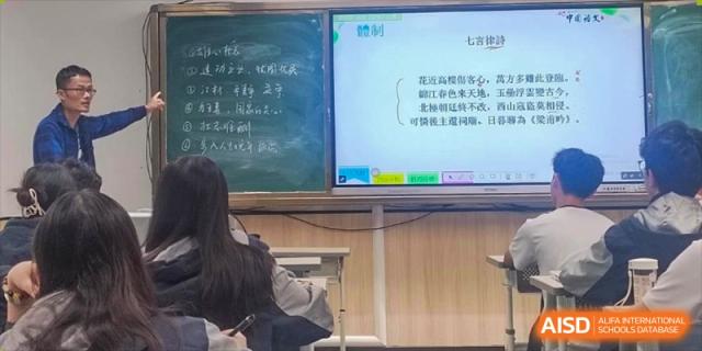 A student's view of the teacher and the content projected on the smart board during a class at the Affiliated School of JNU for Hong Kong & Macao Students.