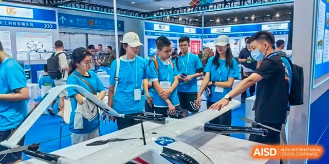 Students from the Affiliated School of JNU for Hong Kong & Macao Students on a field trip, observing a technological exhibit or presentation.