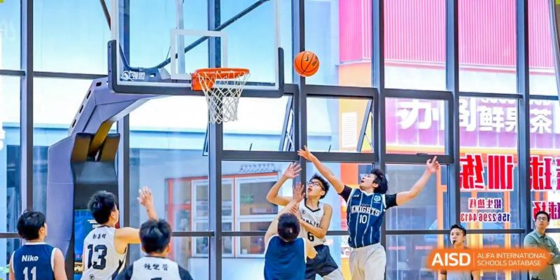 Students from the Affiliated School of JNU for Hong Kong & Macao Students practicing shooting on a bright, modern indoor basketball court.