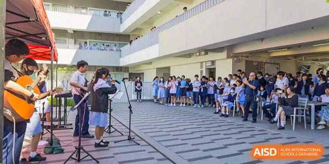 Students from the Affiliated School of JNU for Hong Kong & Macao Students attending an outdoor event or assembly near the school building.