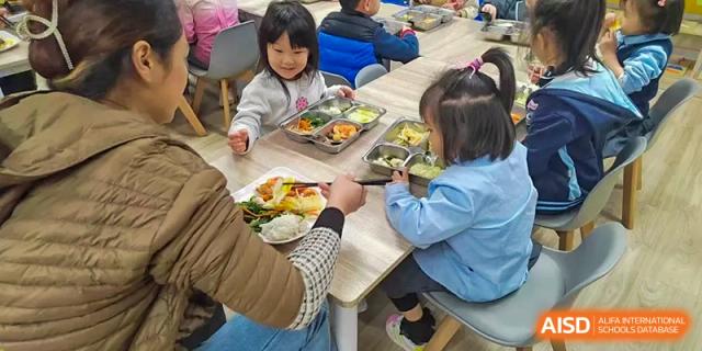Young students from the Affiliated School of JNU for Hong Kong & Macao Students eating their meals in the school dining hall.
