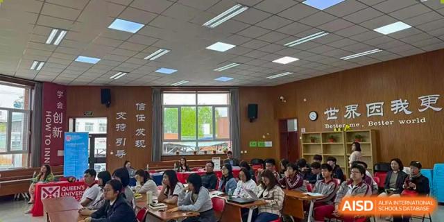 A wide shot of a large classroom full of students attentively listening to a lecture or presentation at Beijing Academy International Department (BAID).