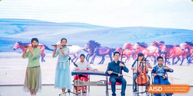 Students performing traditional music with a flute and a guzheng (zither) against a backdrop of horses and a wide landscape at Beijing Academy International Department (BAID).