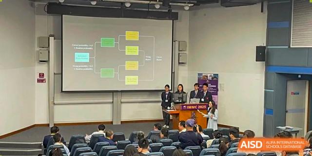 Students and staff attending an indoor presentation or tournament awards ceremony with a large bracket diagram projected onto a screen at Beijing Academy International Department (BAID).