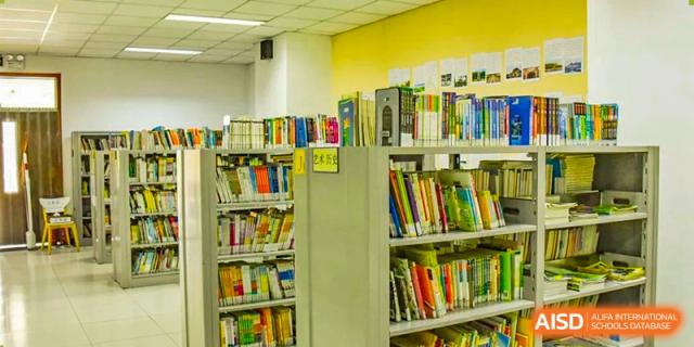 A close-up view of brightly colored bookshelves filled with books in a section of the school library, at Beijing SMIC Private School.