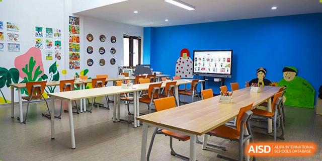 A colorful, collaborative classroom at Boya International Academy (BIA) with an interactive digital screen and movable desks in blue and orange colors.