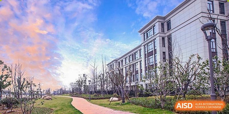 The modern and elegant exterior of one of the main academic or residential buildings at Boya International Academy (BIA) under a blue sky.