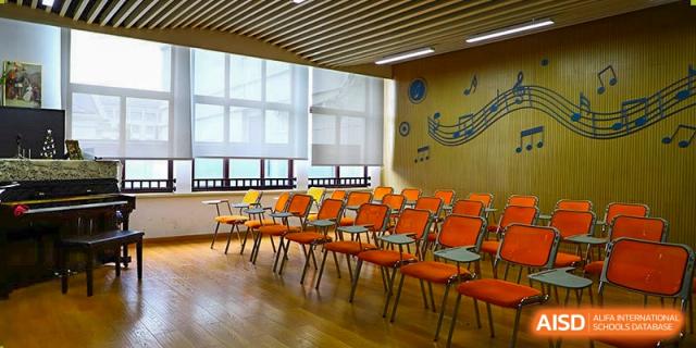 A music or lecture room at Boya International Academy (BIA) with orange chairs, large windows, and a musical staff motif on the wall.