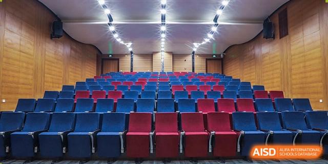 Rows of red and blue seating inside the auditorium at Boya International Academy (BIA).