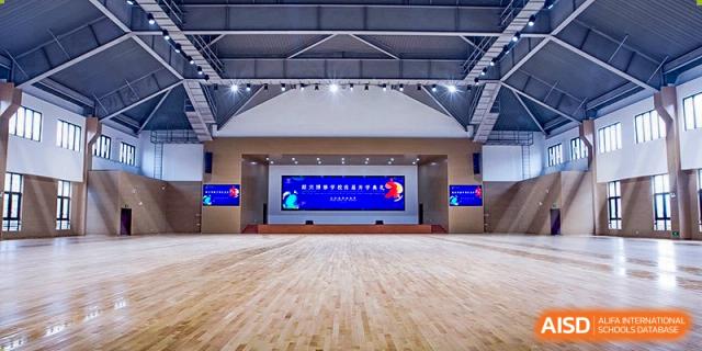 The large wooden stage and backdrop of an assembly hall or auditorium at Boya International Academy (BIA).