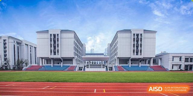 A wide view of the modern academic buildings and the outdoor running track/sports field at Boya International Academy (BIA).