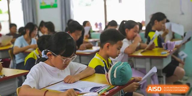 A close-up of a classroom where students are focused on writing or studying during a lesson, Brilliant Light School SJZ.