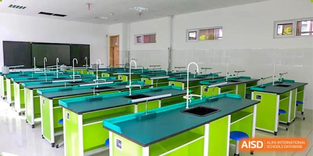 A bright and modern science laboratory classroom with green and white lab tables and sinks, Brilliant Light School SJZ.