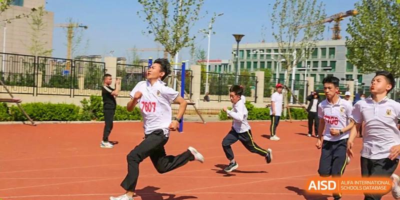 Two students running a race on a red track during a school sports day event, Brilliant Light School SJZ.