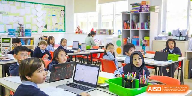 Young students working on individual laptops and computers in an open, collaborative learning space at Britannica International School, Shanghai.