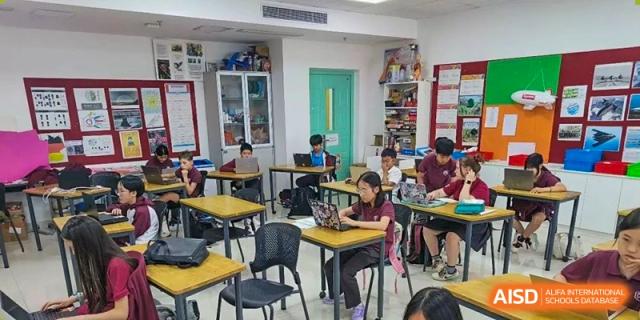 A full view of a modern classroom with students working individually on laptops at their desks at Canadian International School of Hefei.