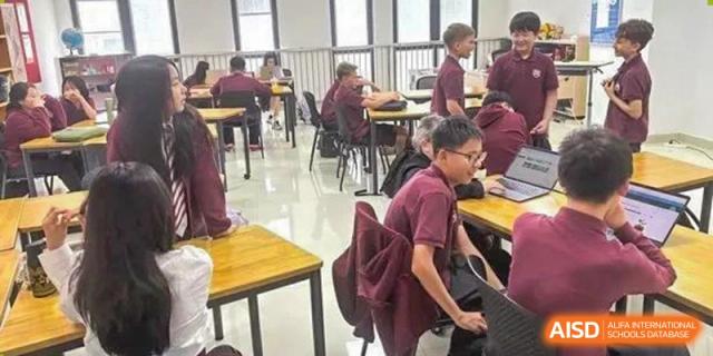Students working independently at desks in a classroom, focused on their laptops and classwork at Canadian International School of Hefei.