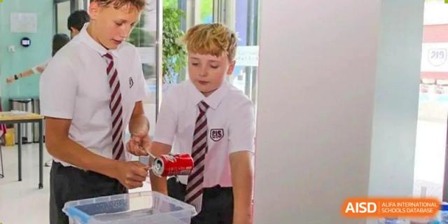 A student in school uniform performing a science experiment with a weight and a stand in a classroom at Canadian International School of Hefei.