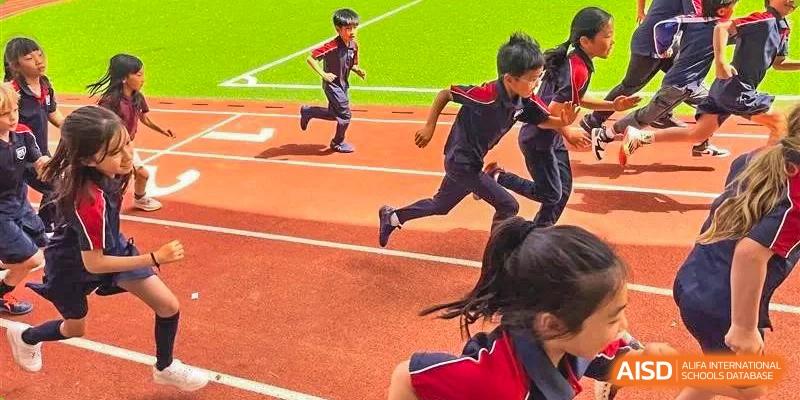 Students running a race on a red outdoor track, focusing on students in the foreground at Canadian International School of Hefei.