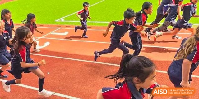 Students running a race on a red outdoor track, focusing on students in the foreground at Canadian International School of Hefei.