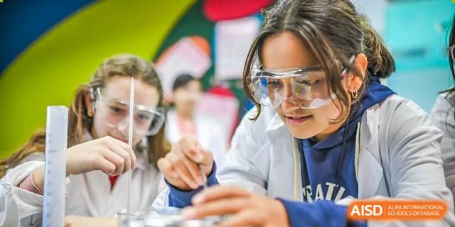 Close-up of a female student from Changchun American International School (CAIS) wearing safety goggles and performing an experiment in the laboratory.