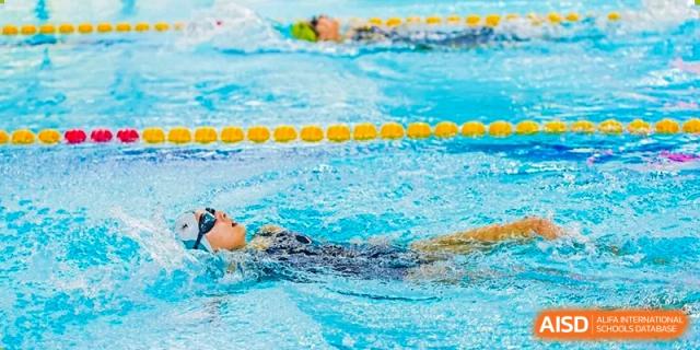 A student from Changchun American International School (CAIS) swimming freestyle during a lap in the swimming pool.