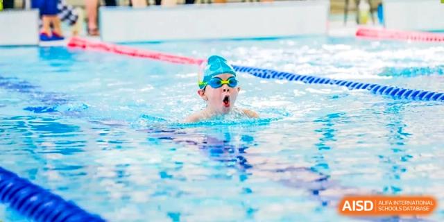 A young student from Changchun American International School (CAIS) swimming in the pool during a practice or lesson.