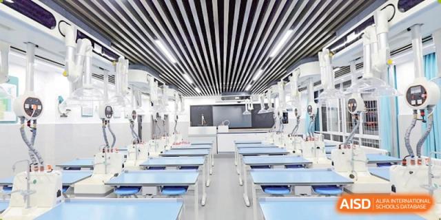 A wide-angle view of a modern, empty science laboratory with sleek white equipment and blue chairs lined up on both sides at Guiyang New World School.