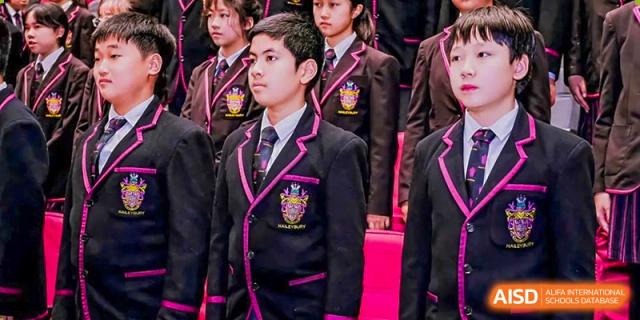 A group of students in their formal school uniforms posing indoors at Haileybury Schools, Tianjin.