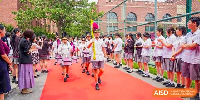 Students in uniform participating in an outdoor sports or running event on the grounds of Haileybury Schools, Tianjin.