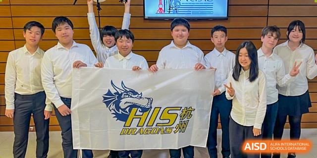 Students and teachers from Hangzhou International School posing with a banner for the 'HIS Dragons' sports team.
