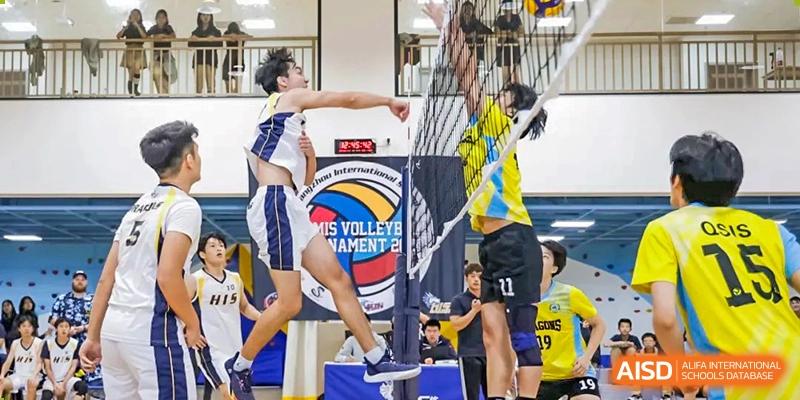 A volleyball player from Hangzhou International School spiking the ball over the net during a competition.