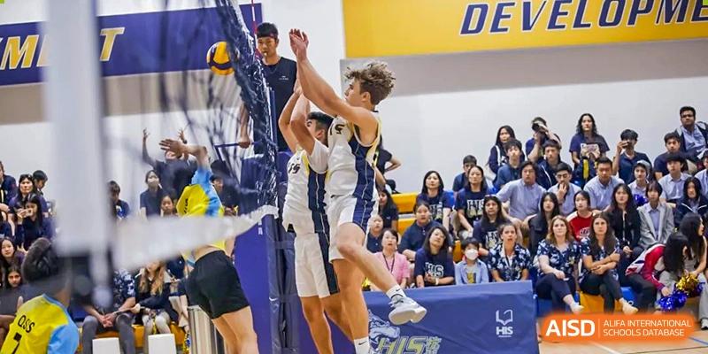 Two male basketball players from Hangzhou International School jumping to block a shot during a game.
