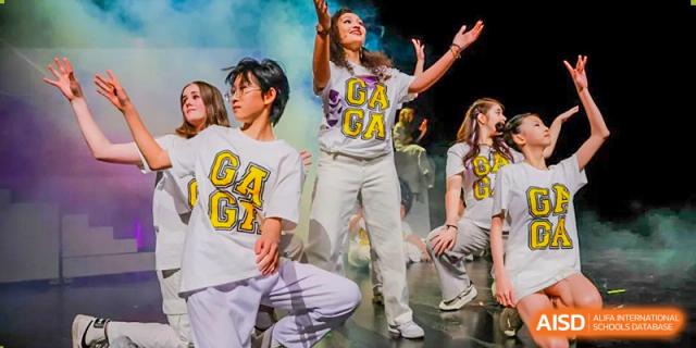Students from Hangzhou International School performing a group dance on stage.