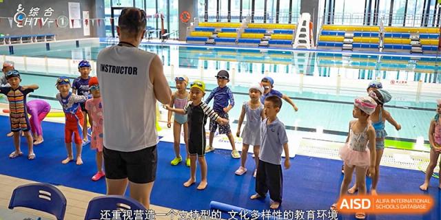 Elementary students from Hangzhou International School in swimsuits standing with an instructor near a pool.