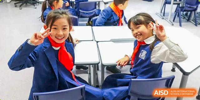 Close-up of students in school uniform seated at desks in a classroom at Harrow LiDe School Chongqing (AISL Harrow Chongqing).