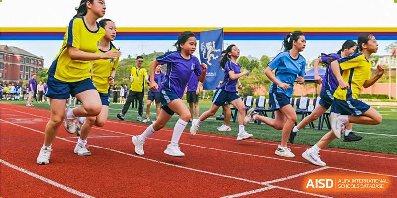A student from Harrow LiDe School Chongqing (AISL Harrow Chongqing) running a race on a red track during a sports event.