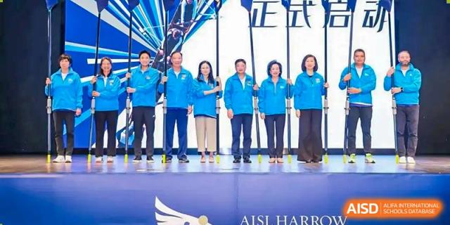 A group of staff or officials from Harrow LiDe School Chongqing (AISL Harrow Chongqing) standing together on a stage, with the "AISL Harrow" logo visible.