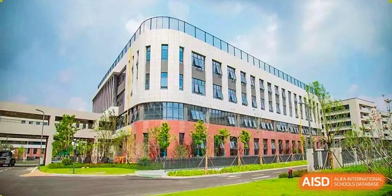 The modern, multi-story school building exterior, surrounded by green lawns on the campus of the Hefei No.6 High School International Department.
